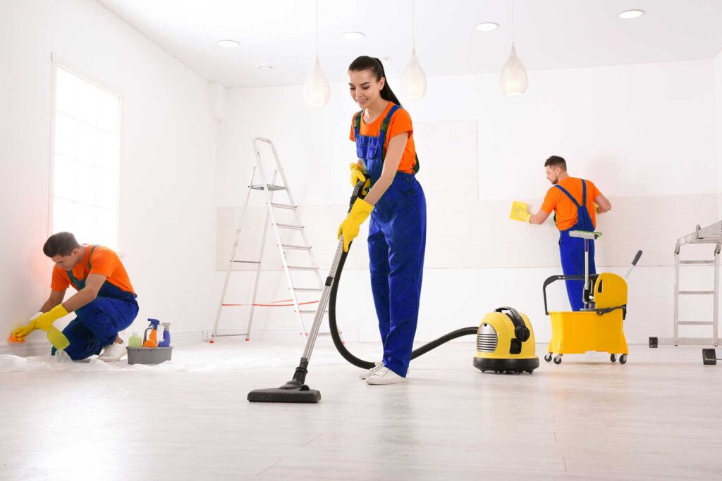 three people cleaning a room